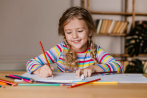 criança em ambiente escolar escrevendo no caderno
