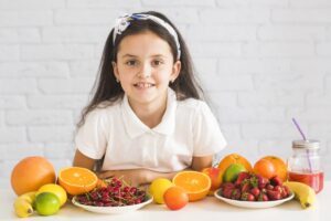 frutas organicas frescas na frente da garota feliz scaled e1677635765665