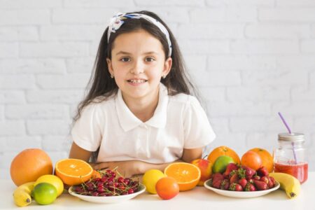 Atividades sobre Alimentação Saudável: Ideias deliciosas e práticas frutas organicas frescas na frente da garota feliz scaled e1677635765665