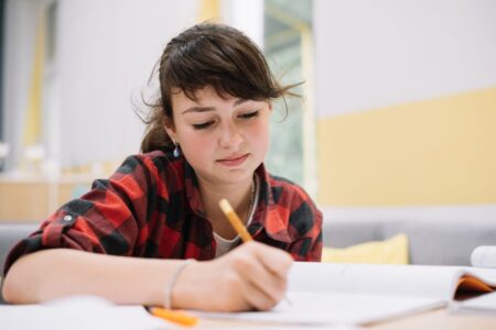 teen girl writing in textbook scaled e1679960731333