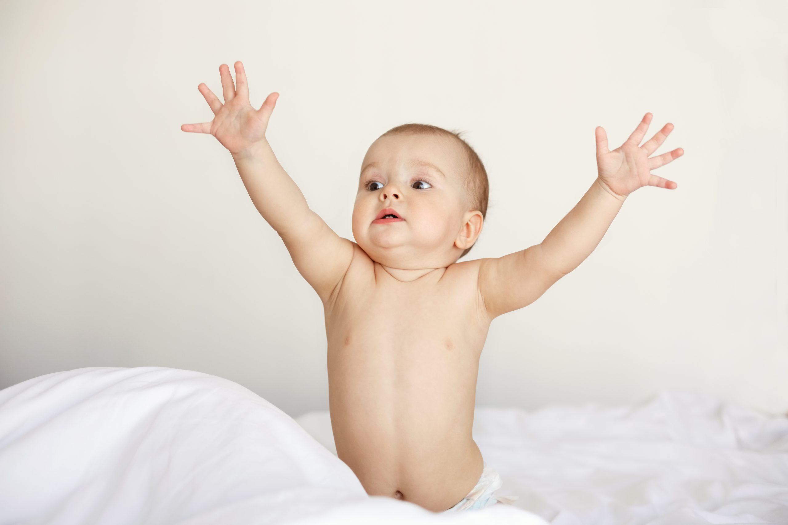 Bebê estica os braços pedindo colo