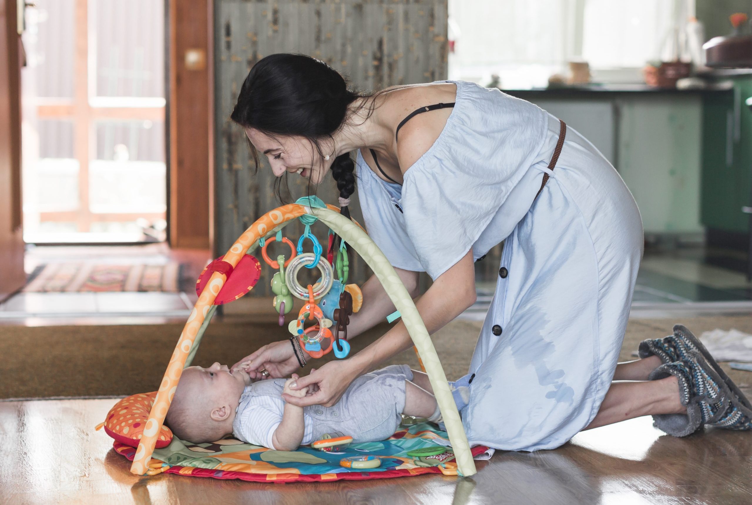 Mulher brinca com bebê em tapete  de atividades