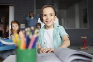 crianca sorridente de tiro medio no jardim de infancia scaled e1691695582332