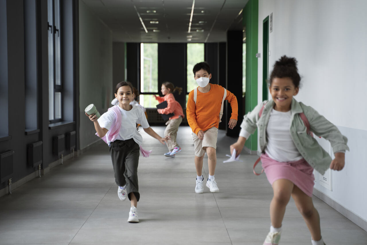 Crianças correndo na escola enquanto brincam