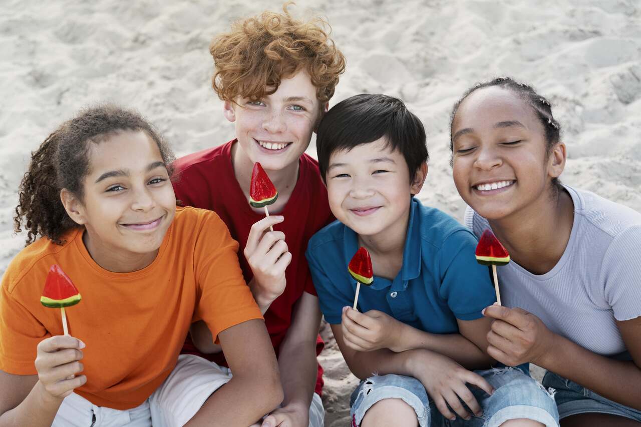 Crianças com sorvete de melancia na praia
