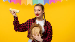 Mulher vestida para Festa Junina segurando milho