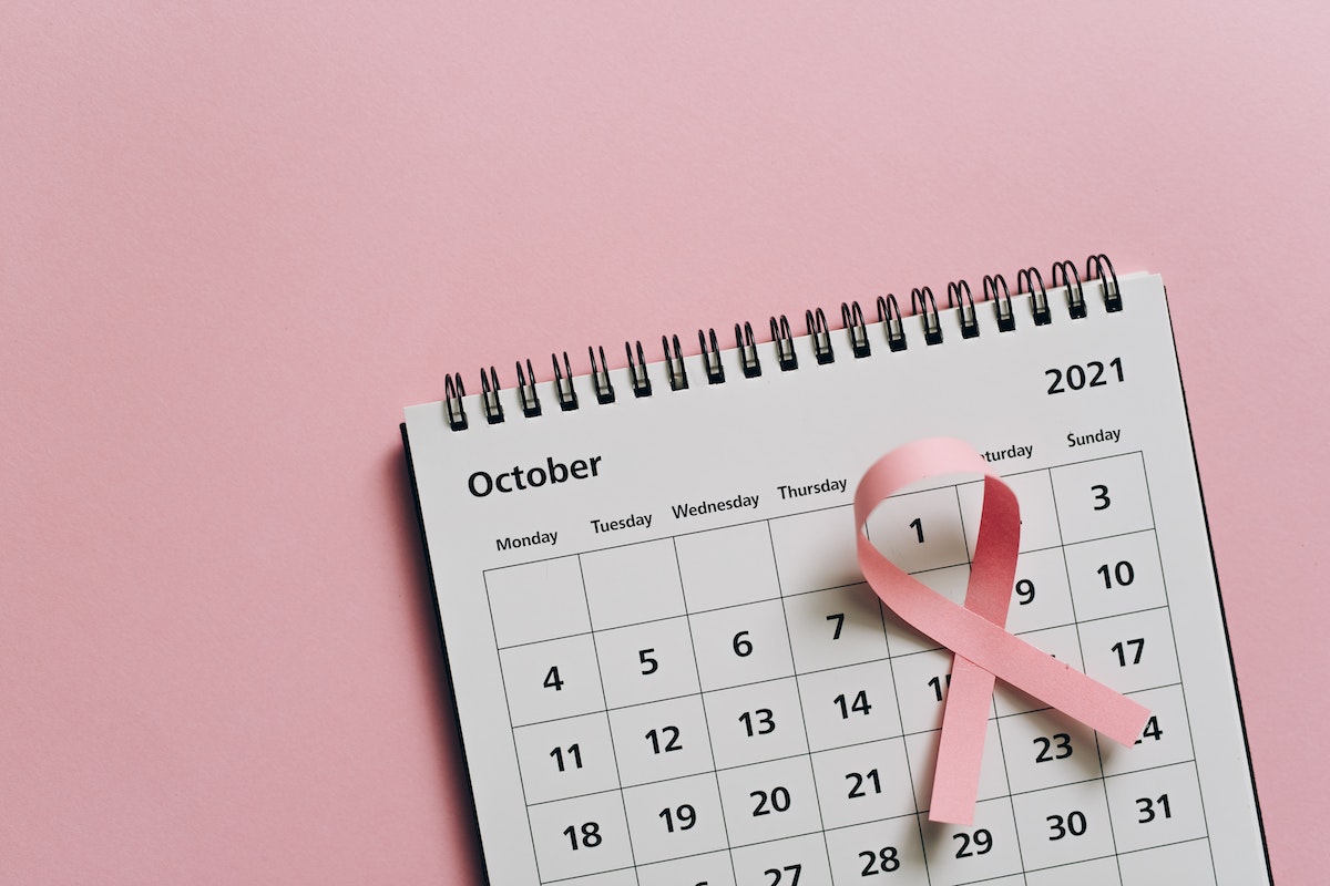 Um calendário que está com uma fita rosa destacando o dia 1º de outubro