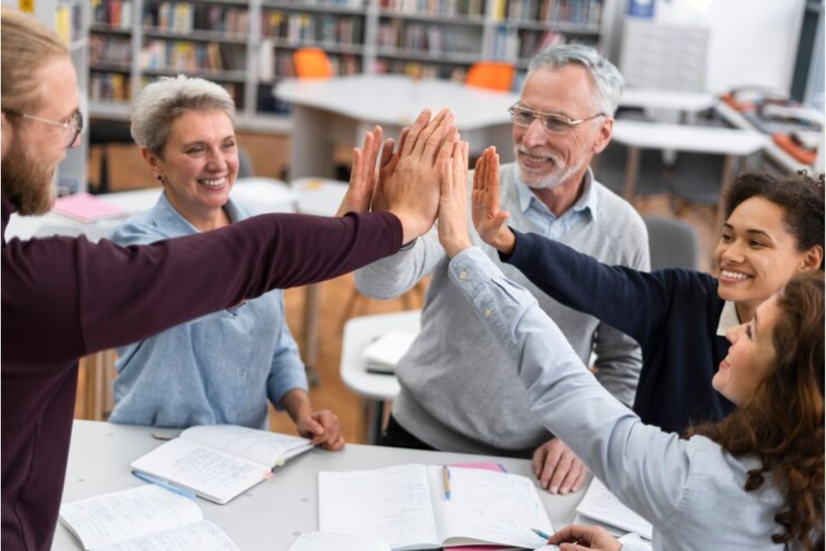 Um grupo de professores tocando as mãos após uma reunião