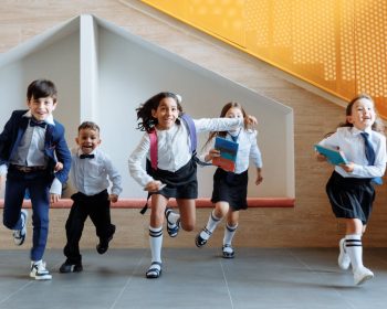 Crianças estão correndo na escola para chegar na sala de aula