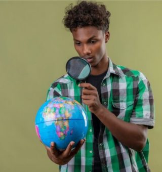 Um aluno está segurando uma luoa enquanto olha para um globo terrestre