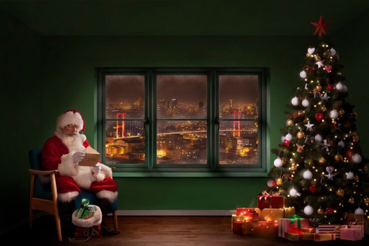 Imagem de um quarto decorado onde o Papai Noel está sentado