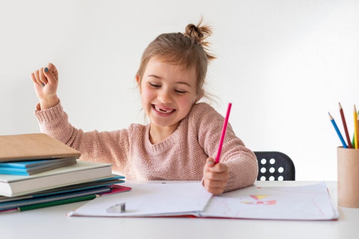 Uma criança está feliz enquanto desenha em seu caderno 